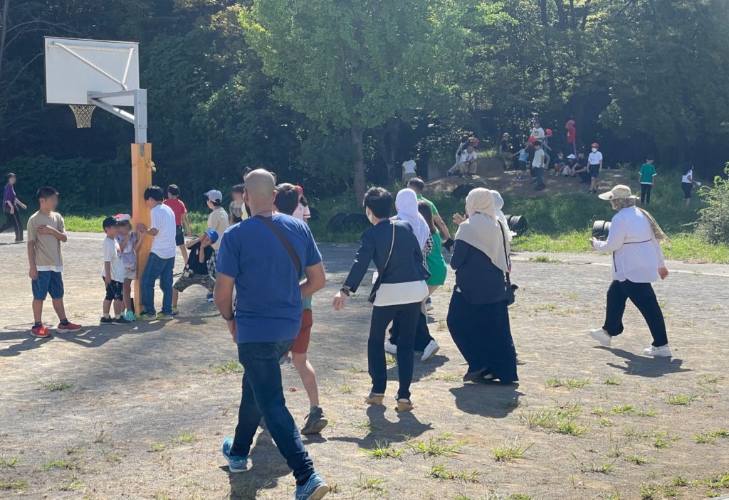 子供たちと一緒に「だるまさんがころんだ」をして遊ぶ研修メンバー